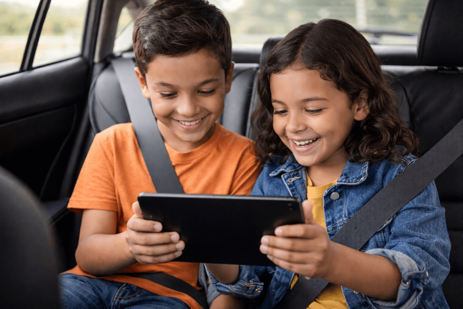 Two children happily using tablets together